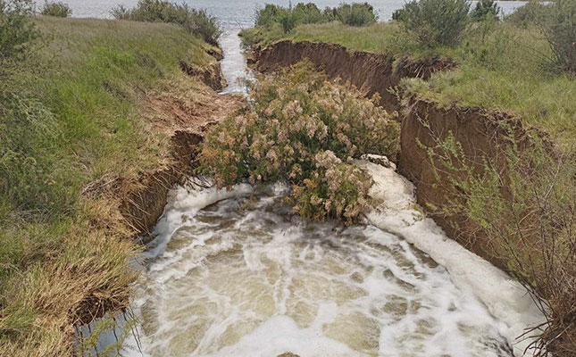 Farmers assessing damage caused to farmland by flooding of mine dam